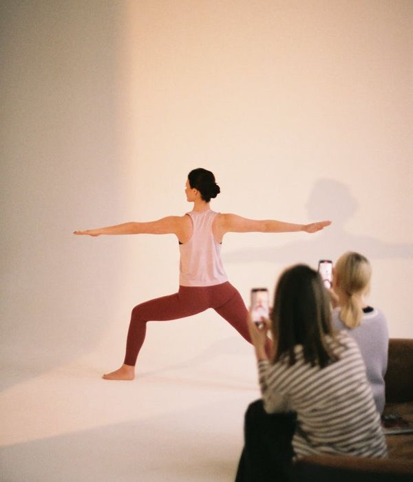 Woman in a calm, balanced pose inside a modern studio.